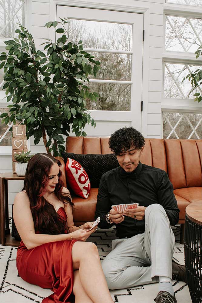 Man and woman playing cards in an intimate, cozy photoshoot at Firefly Haven