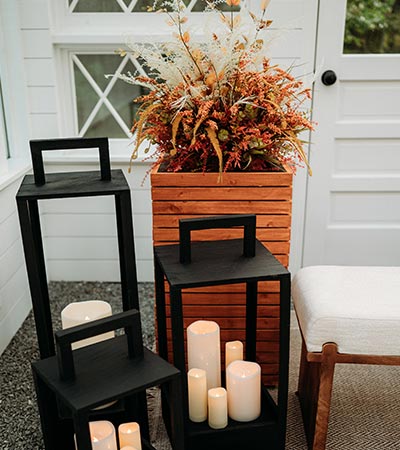 Lanterns, candles, and fall planter boxes inside of Firefly Haven