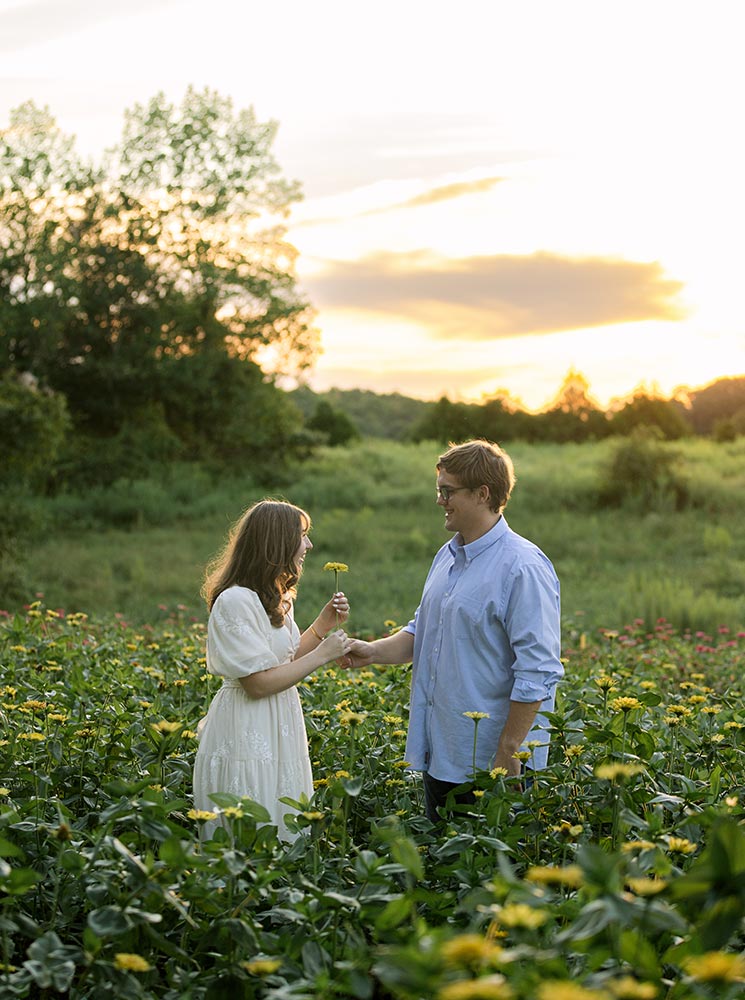 realtor-002 Engaged couple within a yellow zinnia field at Firefly Haven. Taken by Ashley Logan Photography.